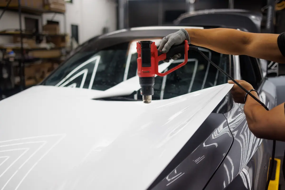 Installer heat-forming protection film on a car bonnet
